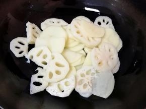 下入土豆和莲藕翻炒至变色。