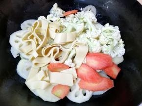 下入菜花、红萝卜和豆腐皮翻炒均匀。 