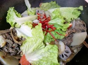 下入生菜叶和辣椒包里的的红辣椒翻炒均匀出锅(辣椒也根据自己的口味放，我没有放完)。 