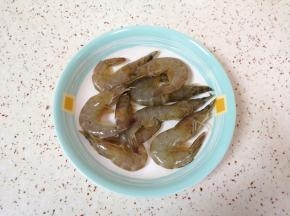 虾洗干净剪去虾枪虾脚，放点料酒和酱油腌制一下。