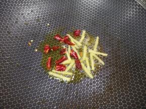 锅里继续倒油烧热，下入姜丝和干红辣椒炒香。