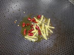 锅里继续倒油烧热，下入姜丝和干红辣椒炒香。