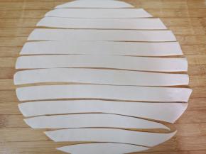 擀成2-3毫米厚度的大面片，用刀划开成长条状，盖上保鲜膜备用。