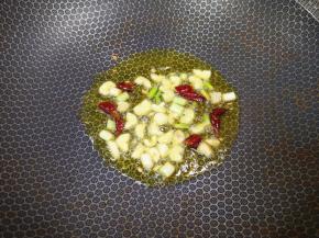 炒锅内倒适量的食用油烧热，下入葱、蒜和干红辣椒炒香。