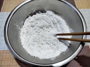 糯米粉中加入100-110克刚烧开的水，一边倒，一边用筷子搅拌。
