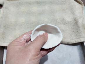 取一个小面团，先压扁，然后两手的大拇指在中间，其余手指在另一面，一边捏一边转圈。捏成一个小碗状，中间厚一点，边缘薄一点。不要太大力，容易捏破了。