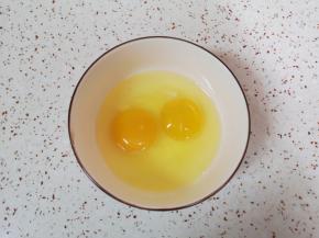 鸡蛋磕入碗里。 