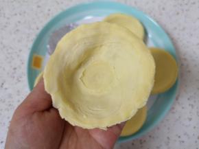 蛋挞皮解冻比较快，趁着蛋挞皮硬的时候从锡纸壳里取出，将边缘捏扁。