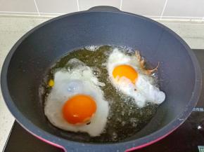 锅里多放一点食用油，油温五成热放入鸡蛋煎，这样它的外皮特别好吃，焦焦的。