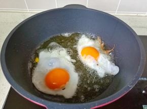 锅里多放一点食用油，油温五成热放入鸡蛋煎，这样它的外皮特别好吃，焦焦的。
