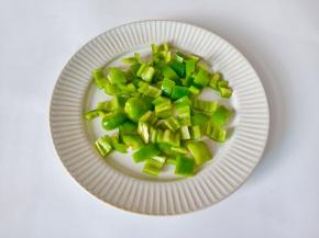 青椒对半切开去籽，再切成小丁。