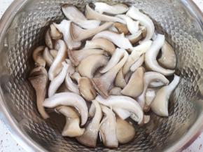 蘑菇切去根部，撕成小块用淡盐水浸泡一下。