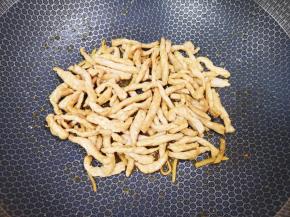 炒锅内倒适量的食用油烧热，下入腌好的肉丝大火翻炒至变色，盛出备用。