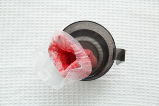 9、巧克力装入裱花袋或者高一些的容器，隔水融化成液态。杏仁脆片掰成碎片。