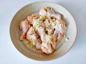 把鸡腿放入容器里，加入姜蒜末。