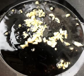 锅中倒入底油加热放入蒜粒爆香