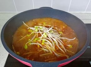 再加入适量的开水煮开，放入豆芽煮熟。