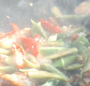 加入姜末、蒜苗白，尖椒炒匀