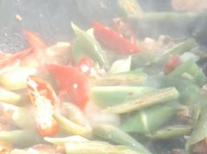 加入姜末、蒜苗白，尖椒炒匀