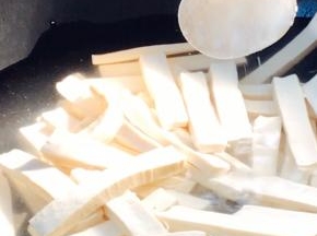 白豆腐干洗净切条，冷水下锅，加少许盐煮沸后捞出备用