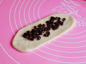 取一块醒好的面团擀开，撒上蜜豆。