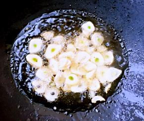 锅中放入底油加热至七成熟火不要太急放入蒜片炸香