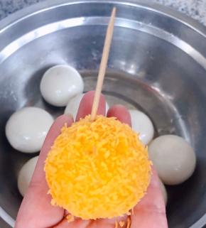 裹好面包糠的黑芝麻汤圆用牙签扎几个透气孔