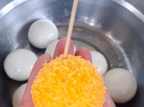 裹好面包糠的黑芝麻汤圆用牙签扎几个透气孔
