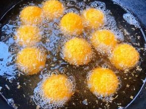 锅中倒入适量油加热至五成热放入黑芝麻汤圆中火炸起来