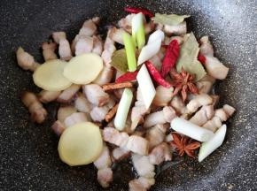 下入葱、姜、干红辣椒、八角、桂皮和香叶炒出香味。