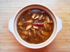 将炒好的五花肉和笋干倒入砂锅，加开水没过五花肉。