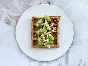 把奇异果去皮，先切成片，再切成小扇形，摆放到华夫饼上，再撒上即食燕麦脆。