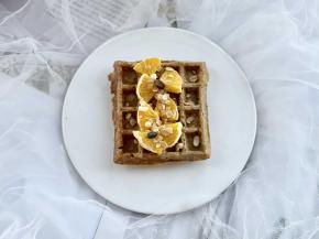 和奇异果同样的方法切出扇形的橙子片，摆到华夫饼中间，撒上即食燕麦脆和果干。