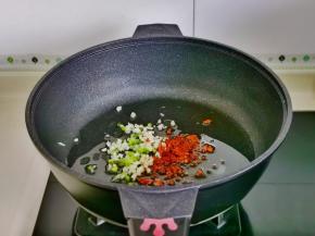 起油锅，加入切好的葱蒜辣椒碎煸炒。