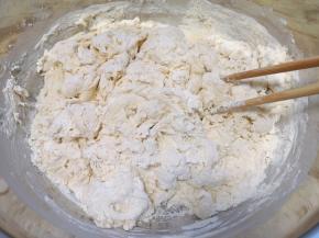 分次加入面粉中，用筷子搅拌成絮状。 