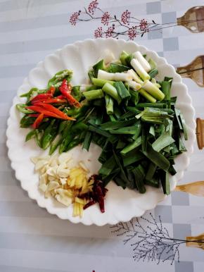 蒜苗把蒜白拍一下，然后把蒜苗切成段，螺丝椒切成块，蒜瓣切成片，生姜切成丝，干辣椒切成段备用！