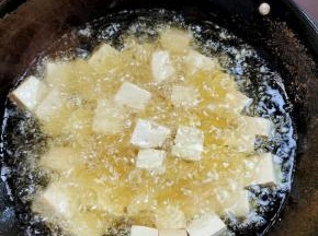 起锅烧油，油温七成热（拿一支木筷子插在油中，筷子周围冒泡泡就说明油温可以了！），放入切好的豆腐，用漏勺稍微推动一下，进行炸制！