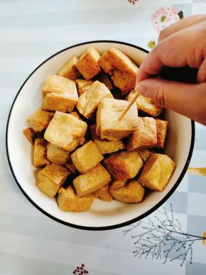 炸好的豆腐泡放入碗中，用牙签把豆腐泡扎几个小孔，方便入味儿！