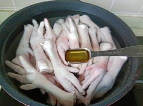 鸡爪冷水下锅，放入料酒两勺。