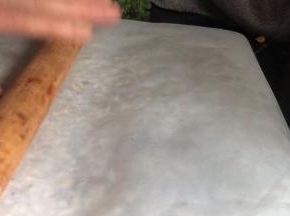 盖上油纸，用擀面杖擀压平实