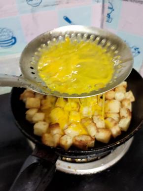 借助漏勺，把蛋液均匀的淋在馍丁上！