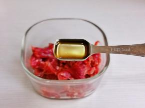 切好的牛肉放入器具中，加入料酒。