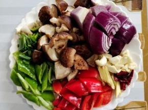 准备好所需的配菜：
青椒和红椒去蒂洗净切成块，泡发好的香菇切成小块，洋葱切成块，蒜瓣切成小块，生姜切成丝，干辣椒切成段备用！