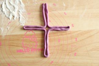 取一面团搓成80CM长条，撒粉防粘。整理成十字形。接着按图整形即可。