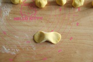 取一搓成中间胖两头瘦的长条，两头用掌心力量按扁。