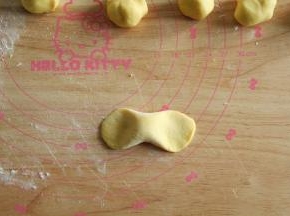 取一搓成中间胖两头瘦的长条，两头用掌心力量按扁。