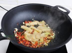 炒锅烧热，倒入适量花生油，放大蒜、生姜、干辣椒、红辣椒，小火煸炒香。接着放入酸笋，继续煸炒至酸笋的香味。