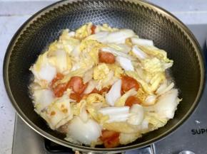 再下入白菜，加半碗清水翻炒片刻。