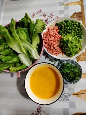 青豆焯水捞出沥干水分，火腿肠切成小丁，螺丝椒去蒂切成小丁，香菜切成段。生菜洗净，土鸡蛋打散备用！