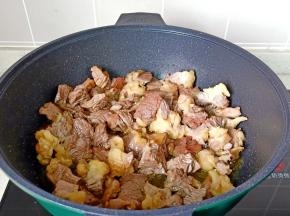 锅里放适量的食用油，开小火放冰糖炒出糖色，放入牛腩翻炒。